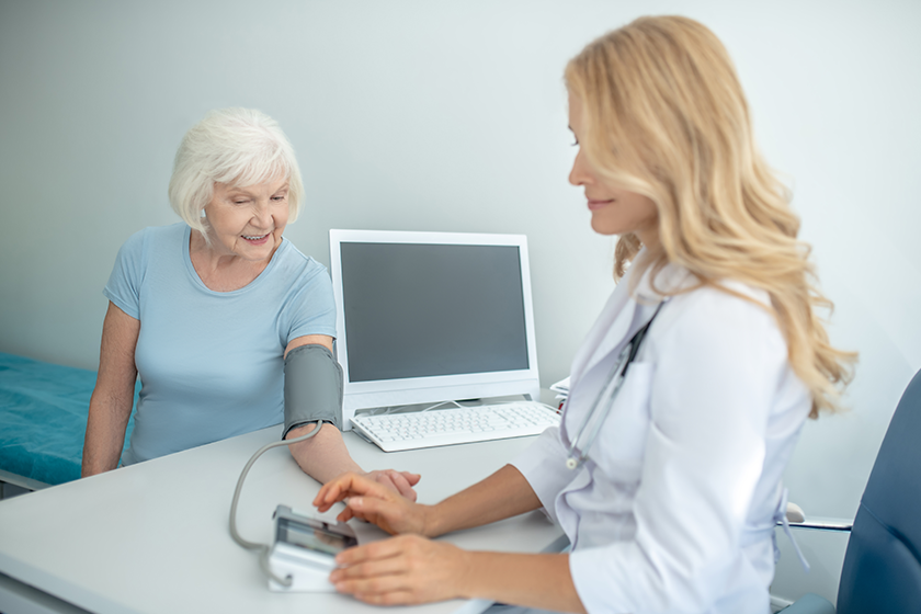 Female cardiologist measuring blood-pressure