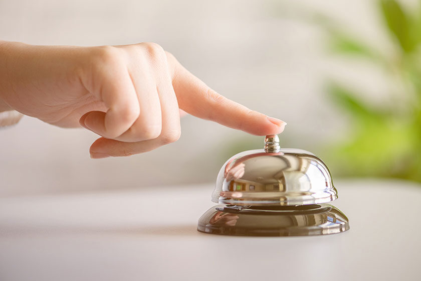 Hand of guest ringing in silver bell