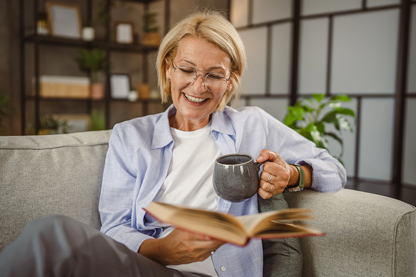 Mature woman sit in the living room read a book