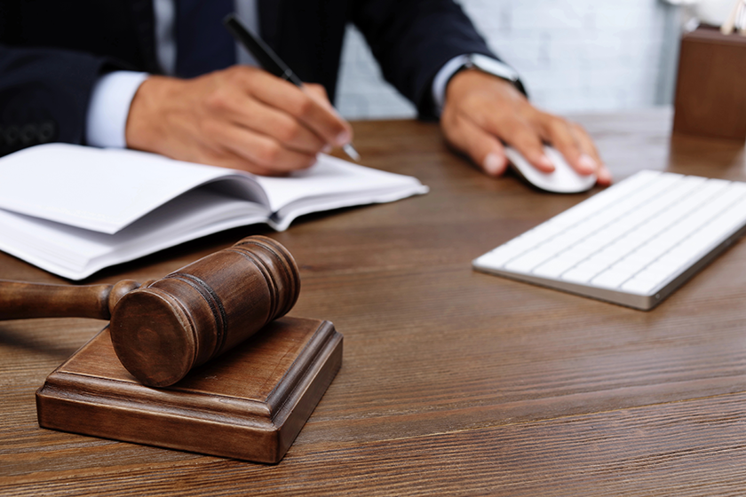 Wooden gavel and blurred lawyer on background. Notary services 